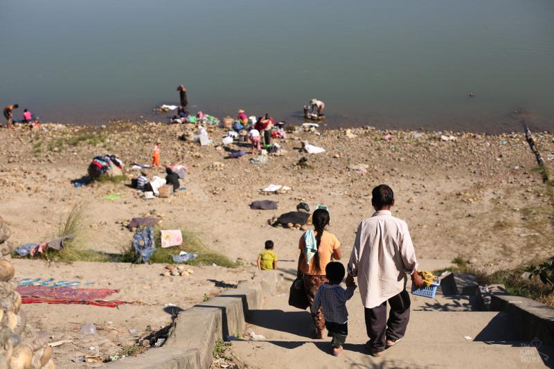 Families wash by the riverside in Myitkyina, the capital of Kachin state